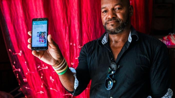 Emilio Roman, father of two young men and a daughter who were imprisoned and accused of participating in the July protests against the government, shows a picture of his children at their home in La Güinera neighborhood of Havana, March 29, 2022.