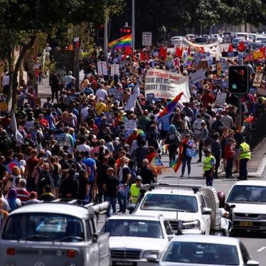 Police watch marchers holding signs and banners as they participate in a marriage equality march in central Sydney, Australia.