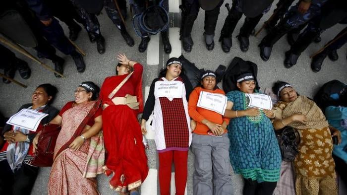 Women activists lie down on the road during a protest demanding women’s rights in the constitution in Kathmandu, Nepal, August 7, 2015.