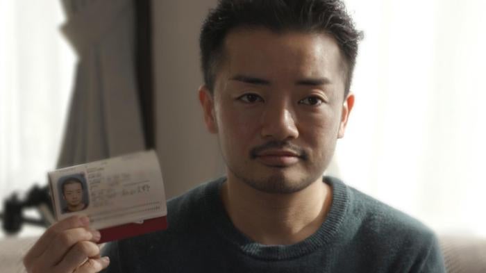 Fumino Sugiyama, a transgender man, holds his Japanese ID card, which reads “female,” at his home in Tokyo.