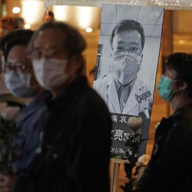 People wearing masks, attend a vigil for Chinese doctor Li Wenliang, in Hong Kong, February 7, 2020.