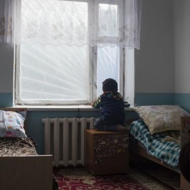 A child stares out a bedroom window