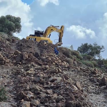 child plays next to an earth digger 