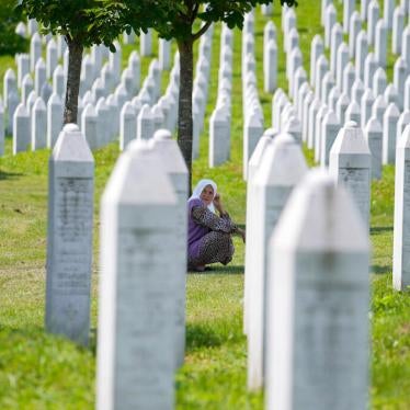 A woman among the graves of victims of the Srebrenica genocide, at the memorial cemetery in Potocari, near Srebrenica, Tuesday, June 8, 2021.