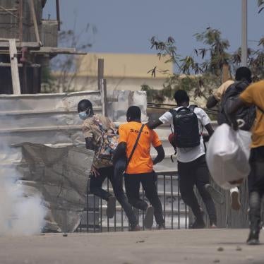 People flee teargas thrown by riot police during a protest against the proposed counterterrorism law and penal code reform at the Cheikh Anta Diop University campus in Dakar, Senegal, June 25, 2021. 