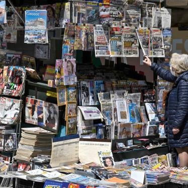 A woman reads newspaper's headlines referring to the killing of a Greek journalist in Athens on April 10, 2021.