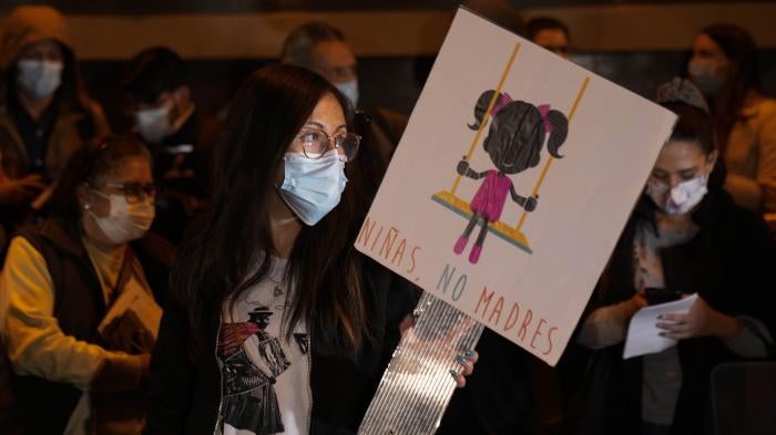 A woman holds a banner that reads in Spanish "Girls, not mothers," during a demonstration calling for sexual and reproductive rights in La Paz, Bolivia, on Oct. 27, 2021. The case of an 11-year-old girl who became pregnant after repeatedly being raped by a family member rekindled the debate on abortion in Bolivia.