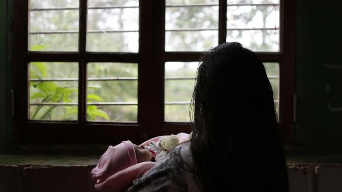 A 13-year-old girl victim of rape in a separate case holds her one-month old baby at a shelter in Ciudad del Este, Paraguay, on May 14, 2015.