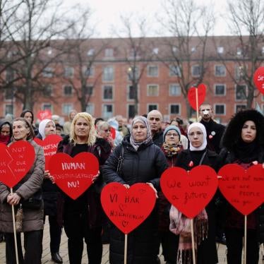 Protesters hold red heart-shaped signs