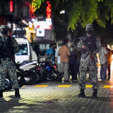 Armed police officers stand in a road