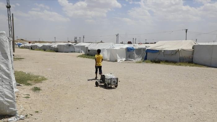 A boy lugs water in Roj camp in northeast Syria.