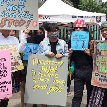 Protesters hold posters on various topics, including opposing mandatory hijab requirements for girls in state schools, during the Women’s March in Jakarta, March 2020.