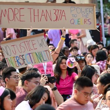 Demonstrators hold pro-LGBT signs at a rally