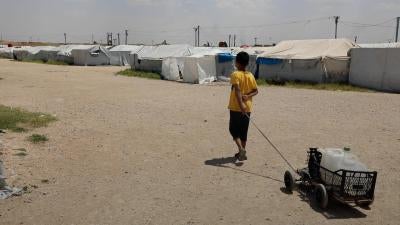 A boy drags a cart