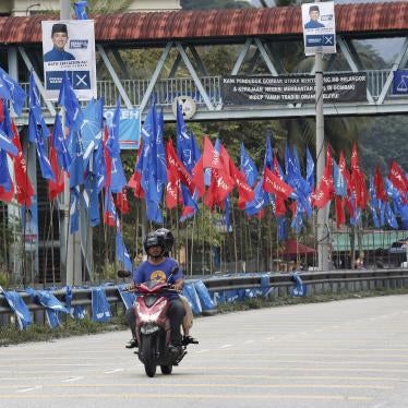 Motorcyclists ride past political party flags in Kuala Lumpur.