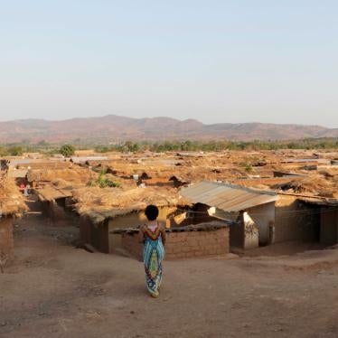 A woman watches children playing at Dzaleka Refugee Camp in Dowa, Malawi. 