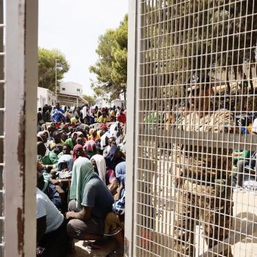 People sit on the ground of the overcrowded migrant reception center on Lampedusa, an Italian island in the Mediterranean Sea, on September 16, 2023.