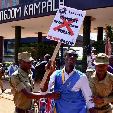 security officials detain a protester holding a placard