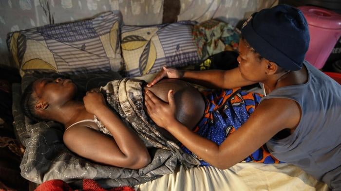 A traditional birth attendant assists in delivering a woman’s baby in Kibera, Nairobi, Kenya, 2020. 