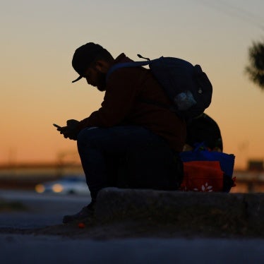 A seated man using a cell phone