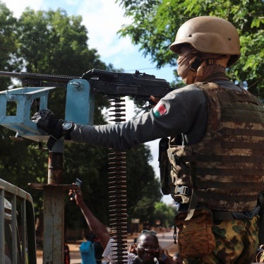 A Burkina Faso soldier stands guard in armored vehicle