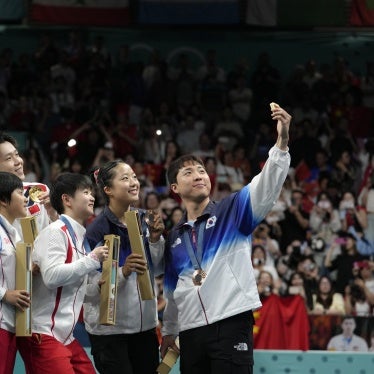 South Korea's Lim Jong-hoon, right, takes a selfie with other table tennis Olympians, including North Korea's Ri Jong Sik, left, and Kim Kum, second left, during the medal ceremony at the 2024 Summer Olympics in Paris, France, July 30, 2024.