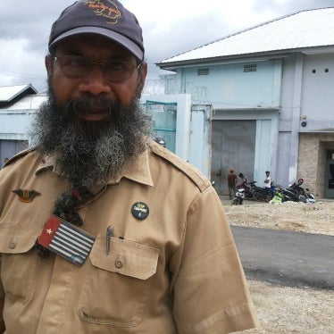 A man poses for a photo in front of a prison