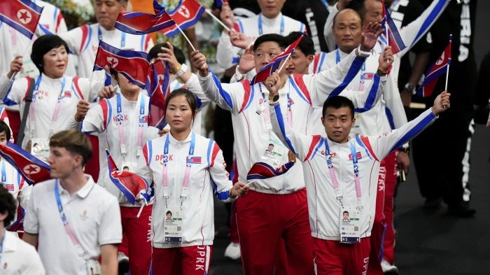 Athletes in uniform wave flags 