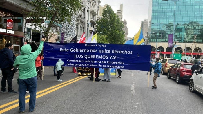 People marching with a banner down a city street