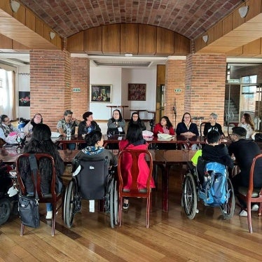 Disability rights activists sit around a table for a meeting