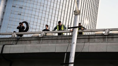 Workers are seen at the Sitong Bridge in Beijing on October 14, 2022, where protest banners with slogans criticizing the Communist Party's policies were hanged the day before.