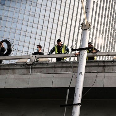 Workers are seen at the Sitong Bridge in Beijing on October 14, 2022, where protest banners with slogans criticizing the Communist Party's policies were hanged the day before.