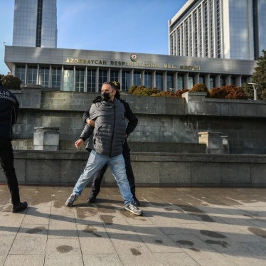 Police Police seize a poster that reads “Journalism is Not a Crime” during a protest by journalists in front of the Azerbaijan parliament building