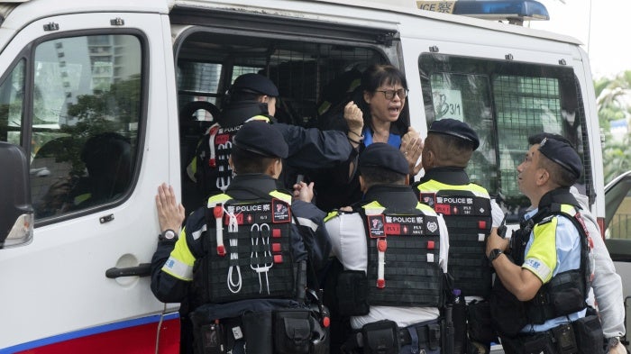 Elsa Wu, foster mother of activist Hendrick Lui, was taken into a police van outside a court