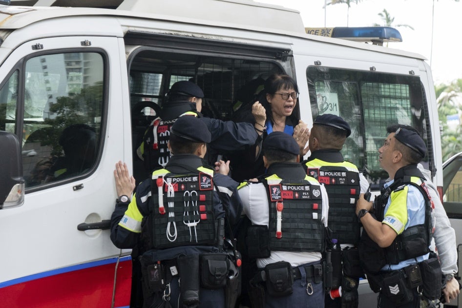 Elsa Wu, foster mother of activist Hendrick Lui, was taken into a police van outside a court